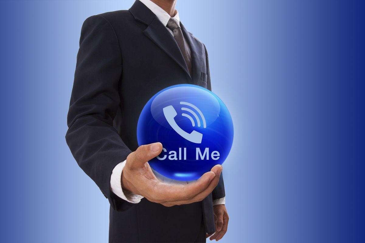 Businessman hand holding blue crystal ball with phone icon.